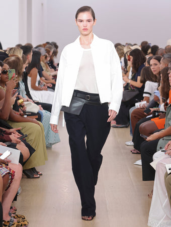 Model Walking Proenza Schouler SS24 Runway In Kiki Tank In White Cotton Mesh, Joey Pant In Navy Brushed Cotton Suiting, Emerson Jacket In White Washed Cotton Poplin, Zip Belt Bag In Black Calf Leather, Tee Toe Ring Sandals In Tan + Black Nappa Lux