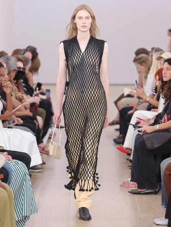 Model Walking Proenza Schouler SS24 Runway In Tauba Dress In Black Satin Ribbon, Roy Jean In Resin Nappa, Flip Shoulder Bag In Birch Nappa Leather, Bronco Chelsea Boots In Black Shiny Calf