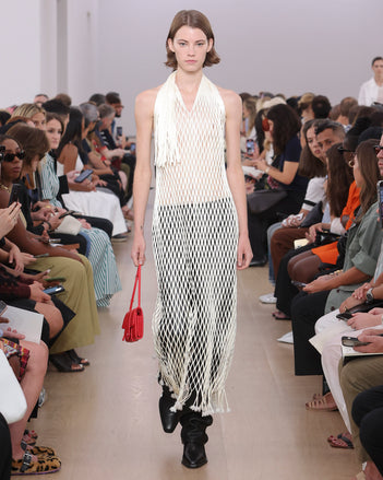 Model Walking Proenza Schouler SS24 Runway In Zora Dress In Ivory Satin Ribbon, Roy Jean In Black Nappa, Flip Shoulder Bag In Red Nappa Leather, Bronco Chelsea Boots In Black Shiny Calf