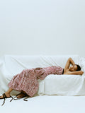 Image of Model laying on covered couch wearing the Maisy Strapless Top in Poplin in Rust/Cream Multi and the Nessa Skirt in Poplin in Rust/Cream Multi with the Tee Strappy Flat Sandals in Kid Suede in Black