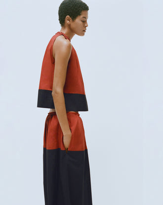 Proenza Schouler editorial image of model wearing the Esme Top in Poplin in Brick/Black with matching Nyla Skirt in Poplin in Brick/Black
