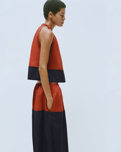 Proenza Schouler editorial image of model wearing the Esme Top in Poplin in Brick/Black with matching Nyla Skirt in Poplin in Brick/Black