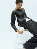 Proenza Schouler Editorial Image of model sitting on a chair wearing Robin Jacket in Leather in Black
