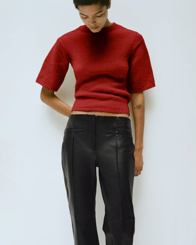 Proenza Schouler Editorial Image of Model wearing the Dana Sweater in Wool in Brick with the Isadora Pant in Leather in Black