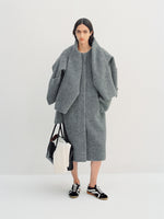 Image of model wearing Albers Coat in Textured Double Face Wool in dark grey multi with Track Sneakers in black/white, carrying Tate Bag in black