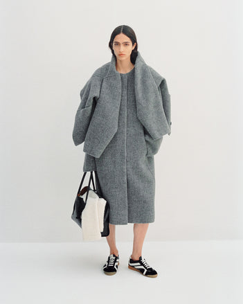 Image of model wearing Albers Coat in Textured Double Face Wool in dark grey multi with Track Sneakers in black/white, carrying Tate Bag in black