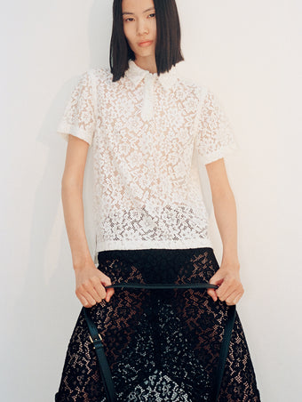 Cropped image of model wearing Kennedy Top in Stretch Lace in off white and Jasmine Skirt in Stretch Lace in black