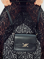 Cropped image of model wearing Jasmine Skirt in Stretch Lace in black, carrying Box Bag in black