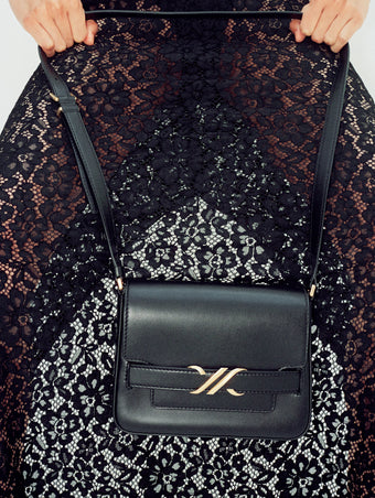 Cropped image of model wearing Jasmine Skirt in Stretch Lace in black, carrying Box Bag in black