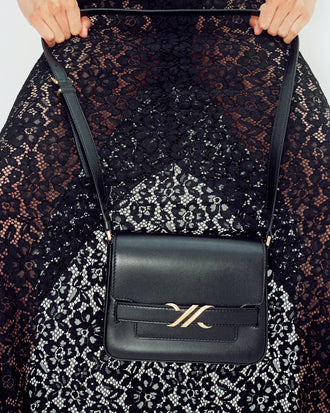 Cropped image of model wearing Jasmine Skirt in Stretch Lace in black, carrying Box Bag in black