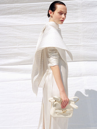 Cropped image of model wearing Hannah Dress in Stripe Silk Twill in ivory multi, carrying Box Bag in cream