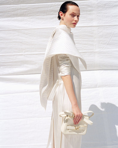 Cropped image of model wearing Hannah Dress in Stripe Silk Twill in ivory multi, carrying Box Bag in cream