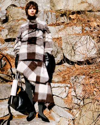 Proenza Schouler Front full length image of model wearing Kai Top In Brushed Glenplaid Knit in Brown Multi against stone background