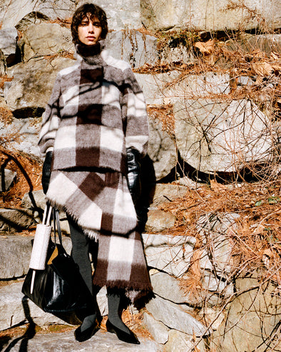 Proenza Schouler Front full length image of model wearing Kai Top In Brushed Glenplaid Knit in Brown Multi against stone background