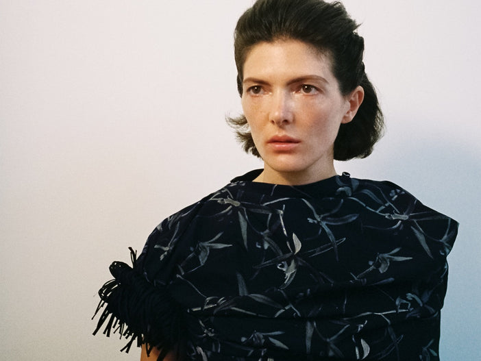 A wide portrait of a model in the Proenza Schouler FW26 Campaign wearing the Bodine dress in Ink multi
