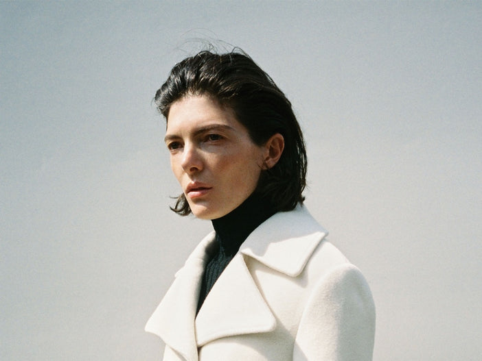 A wide portrait of a model in the Proenza Schouler FW26 Campaign wearing the Romane Jacket