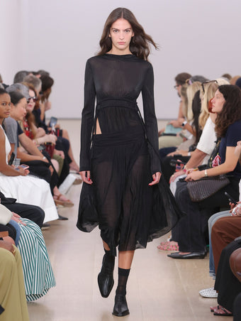 Runway image of model wearing Riley Dress In Pleated Jersey in black
