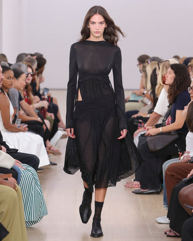 Runway image of model wearing Riley Dress In Pleated Jersey in black