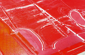 Image of the Ondine Dress in red in the garment dyeing process in the factory 