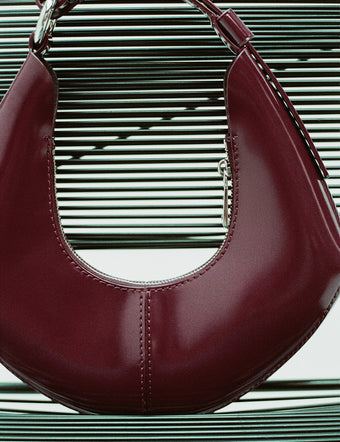 Chrystie Bag in bordeaux sitting against metal slotted chair