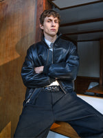 Proenza Schouler Front cropped image of model sitting wearing Sterling Bomber in Leather in Black
