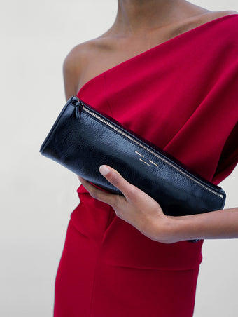 Proenza Schouler Detail image of model wearing Rosina Dress in Light Double Crepe in Scarlet holding a Silo