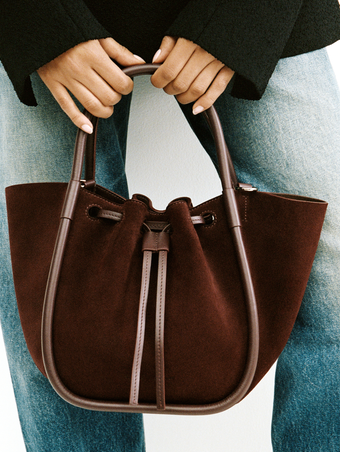 Proenza Schouler Campaign image of model holding the small ruched tote in soft suede in chocolate