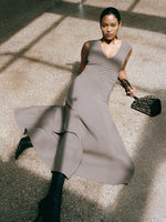 Proenza Schouler Editorial Image of model laying on concrete floor wearing the Romana Dress in Matte Double Crepe in Wood with the Trap Over The Knee Boots - 90mm in Black and the Mini Bucket Bag in Smooth Calf with Grommets in Black