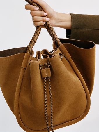 Proenza Schouler editorial cropped image of model holding the Large Ruched Tote in Suede and Braided Calf in Hazelnut 