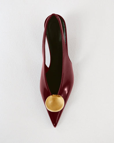 Proenza Schouler Editorial Still Life Image of Dome Slash Slingbacks in Polished Calf in Merlot 