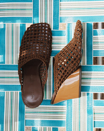 Still life of  slant crochet mules on blue striped beach chair