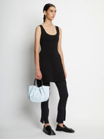 Image of model carrying Small Ruched Crossbody Tote in PALE BLUE by hand