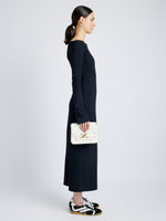 Side image of model carrying Monogram Box Bag in CREAM