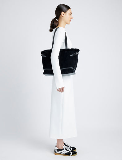 Proenza Schouler image of model carrying Days Tote in Shearling Backed Suede in black