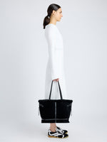 Proenza Schouler image of model carrying Days Tote in Shearling Backed Suede in black