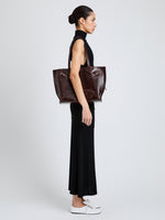 Proenza Schouler Image of model wearing Days Tote in Pull Up Calf Skin in Dark Brown