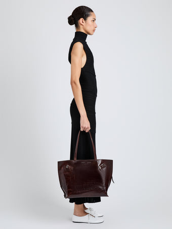 Proenza Schouler Image of model wearing Days Tote in Pull Up Calf Skin in Dark Brown