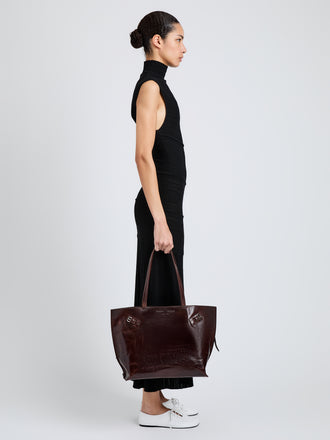 Proenza Schouler Image of model wearing Days Tote in Pull Up Calf Skin in Dark Brown