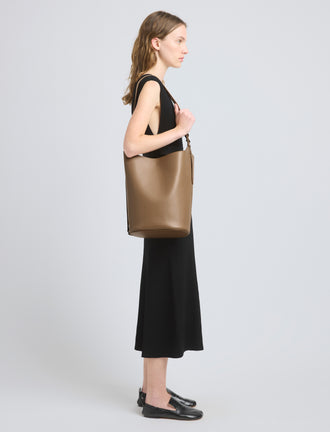 Image of model wearing Brant Bucket Bag in Smooth Calf in Cumin