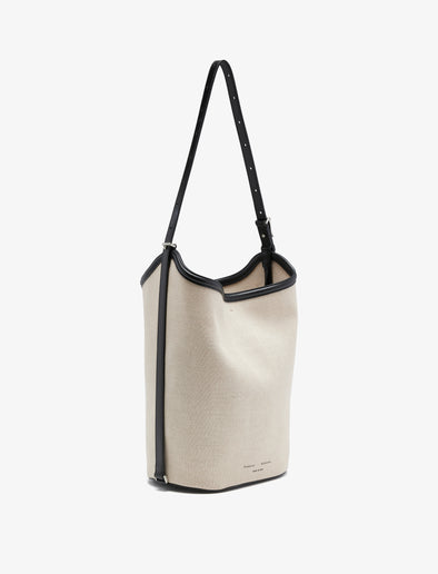 Proenza Schouler front 3/4 image of Brant Bucket Bag in Natural Linen in natural/black