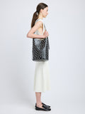 Image of model wearing Brant Bucket Bag in Eyelet Covered Smooth Calf in Black