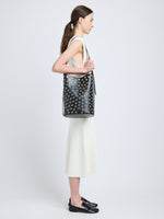 Image of model wearing Brant Bucket Bag in Eyelet Covered Smooth Calf in Black