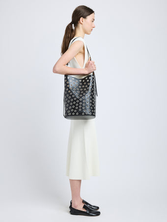 Image of model wearing Brant Bucket Bag in Eyelet Covered Smooth Calf in Black