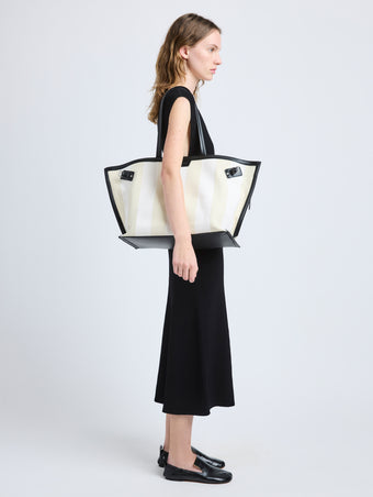 Proenza Schouler image of model carrying Days Carryall in Striped Canvas in resin/white