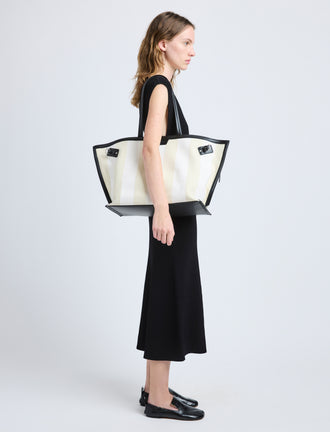 Proenza Schouler image of model carrying Days Carryall in Striped Canvas in resin/white