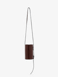 Proenza Schouler front image of Crossbody Silo Bag in Shiny Calf in cedar hanging vertically