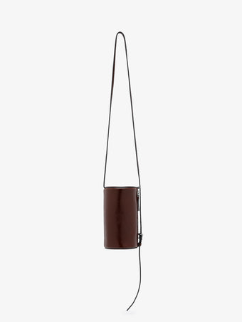 Proenza Schouler front image of Crossbody Silo Bag in Shiny Calf in cedar hanging vertically