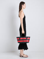 Proenza Schouler Image of model wearing Armory Clutch in Striped Nappa Plonge in TomatoBlack
