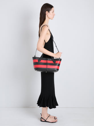 Proenza Schouler Image of model wearing Armory Clutch in Striped Nappa Plonge in TomatoBlack
