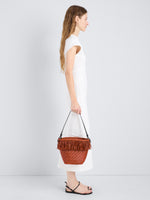 Proenza Schouler Image of model wearing Bucket bag in Raffia in Rust